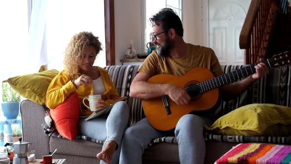 Cheerful adult couple in love together sitting on the sofa in indoor house leisure activity