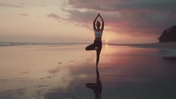 Woman Balancing at Sunset on Beach