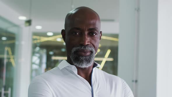 Portrait of smiling african american businessman in white shirt standing in office