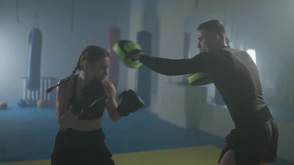 Woman Fighter Trains Punches and Defence Punching Focus Mitts Training Day with a Man Coach in