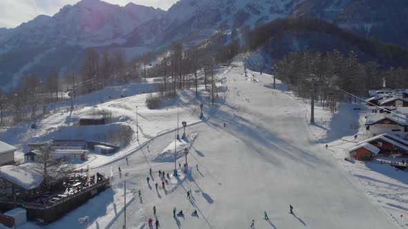 People Are Resting in Ski Resort at Sunny Winter Day Aerial View on Mountain Area with Ski Trail
