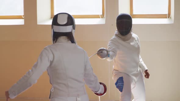 Fencer athletes during a fencing training in a gym