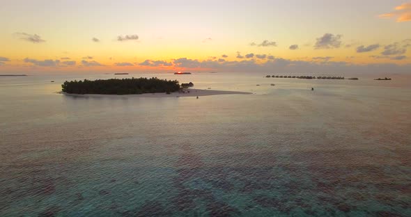 Aerial drone view of a scenic tropical island in the Maldives at sunset