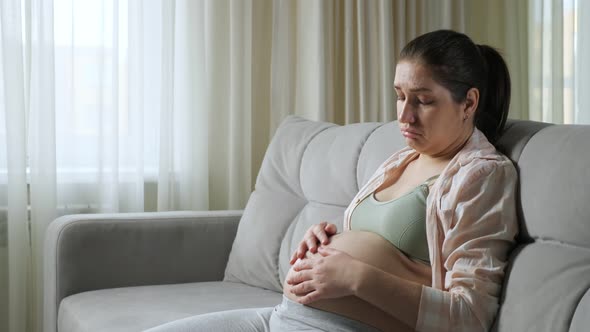Pregnant Woman Sits on Sofa Upset From Gaining Weight