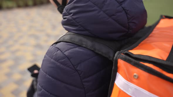 Food Courier Taking Order on Phone During Walk