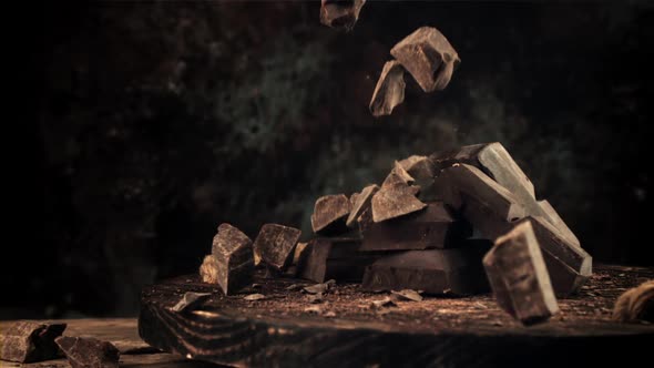 Super Slow Motion Pieces of Dark Bitter Chocolate on the Board