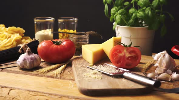 Shredded Cheese with Fresh Basil and Italian Spaghetti on Wooden Kitchen Table