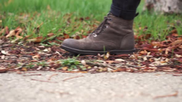 Young Man in Leather Shoes Is Walking Along a Path with Fallen Leaves. Fall Season. Outdoor City