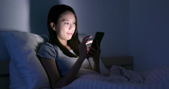 Woman use of smart phone in the evening at home