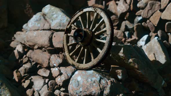 Old Wooden Wheel on Rocks alt
