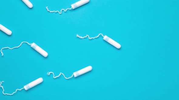 Menstrual tampons move on a blue background. Cotton tampon for women.
