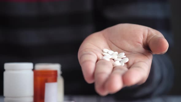 Man's Hand with Medicine Spilled Out of the Pill Container