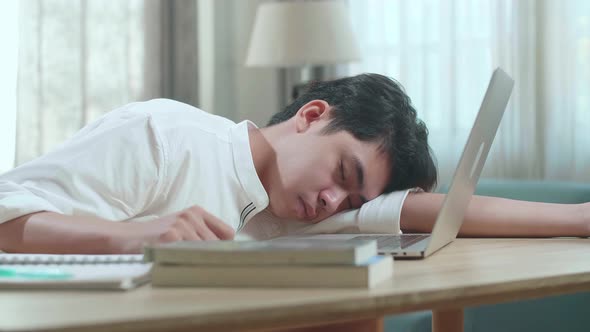 Close Up Of Asian Man Student Sleeping While Using Computer To Study Online At Home