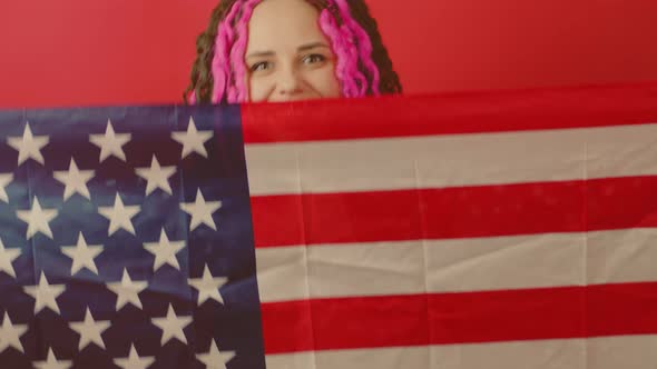 Young Woman with American Flag on Red Background