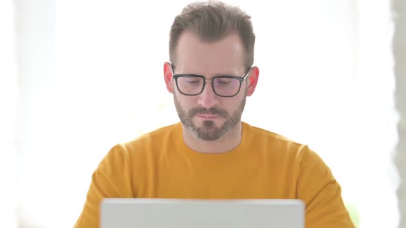 Portrait of Man with Laptop Smiling in Camera