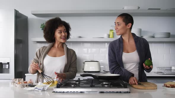 Lesbian couple preparing breakfast in kitchen