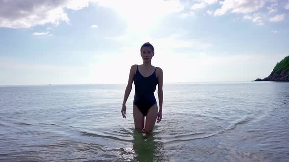Pretty Asian Woman in Black Swimsuit Walking Alone in the Sea Thailand