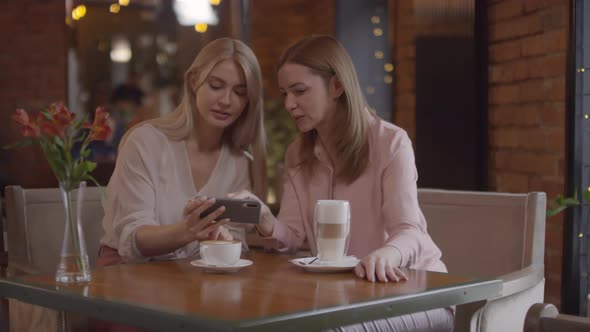 Happy Women Taking Photo of Cappuccino at Cafe