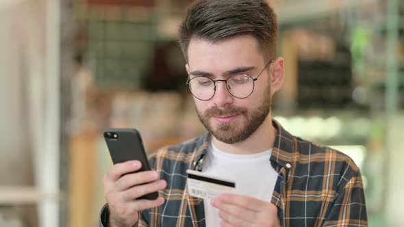 Portrait of Young Man Making Online Payment on Smartphone