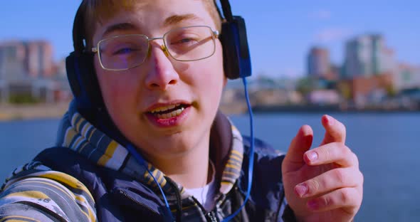 Teenage Blogger in Headphones During an Online Video Broadcast