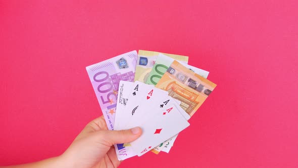 Five of a kind Poker Game cards in gambler hand Euro money bills pink background Lucky combination