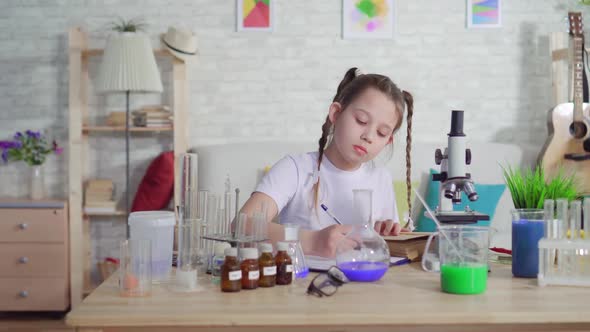 Teenage Girl Reading a Book and Performing a School Project at Home