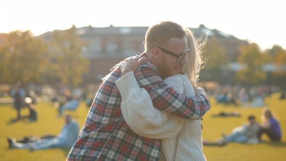 Side View of Happy Senior Mom and Adult Son Hugging in Fall Park