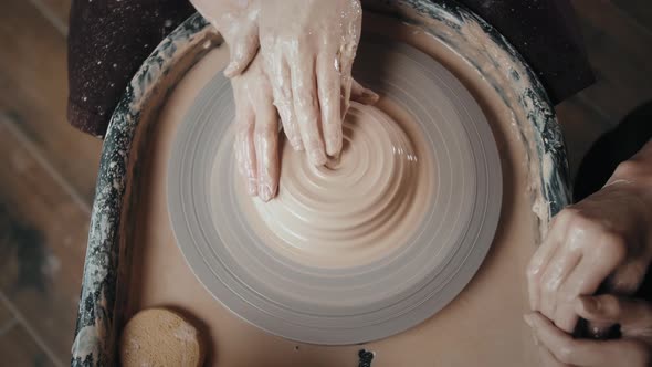 Man Potter Working on Potters Wheel Making Ceramic Pot From Clay in Pottery Workshop