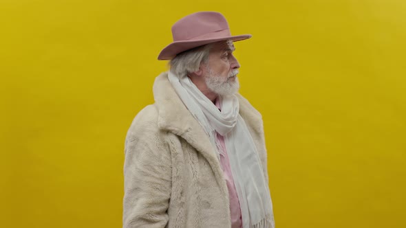 Portrait Of Old Man In Pink Clothes On Yellow Background