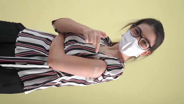 Vertical Video of Young Woman Showing COVID19 Vaccine Bandage Merrily