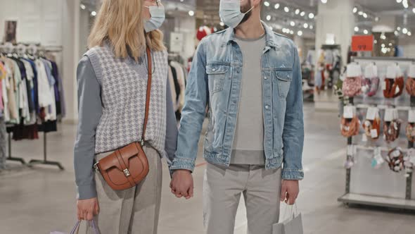 Portrait Of Stylish Couple In Face Masks in Clothing Store