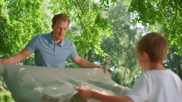 Little Son Help Father Spread Out Blanket