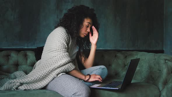 Young African American Woman Feeling Disappointed Reading News Using Laptop at Home