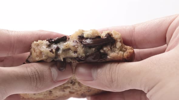 Hands Squeezing Gooey Cookie With Chocolate Coming Out - close up