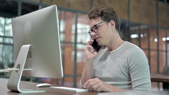 Upset Young Guy Talking and Shouting on Smartphone 