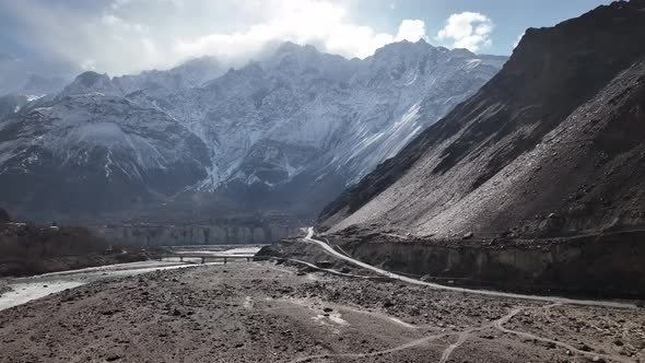Aerial View Of New Section Of KKH Road With Snow Covered Mountain In background. Zoom in