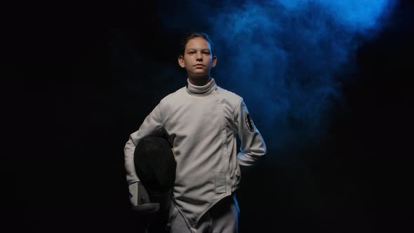 Portrait of Young Guy Swordsman Putting on Protective Mask Helmet