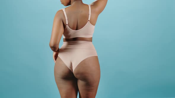 Rear View of Plus Size Woman Dancing Slowly on Blue Background