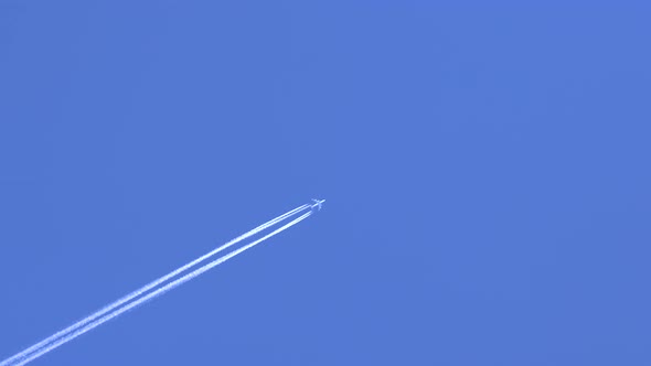 Flying Jet Airplane with Contrails in the Clear Blue Sky