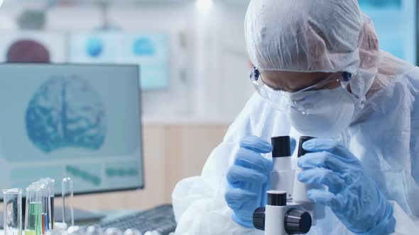 Close Up Shot of Chemist in Coverall Working with a Microscope alt