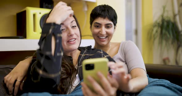 happy lesbian couple smiling and relaxing on the sofa