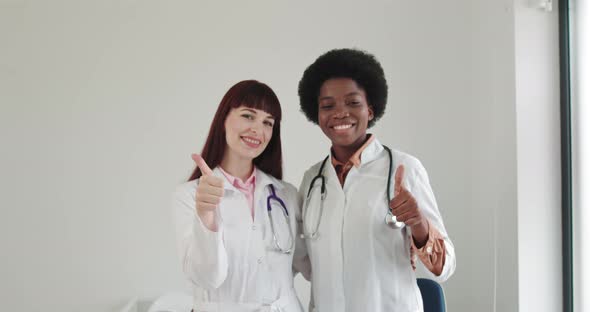 Two Smiling Women Doctors Cardiologist Wearing White Medical Coat And