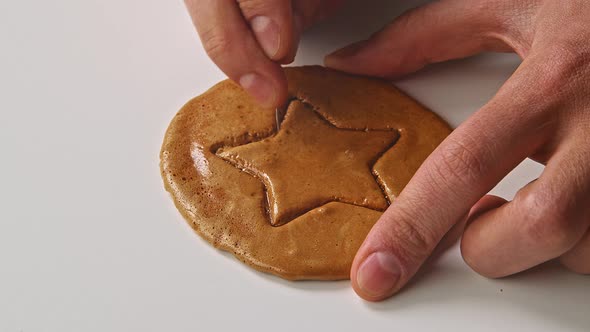 Men's Hands Break Sugar Cookies Candy in the Shape of a Star