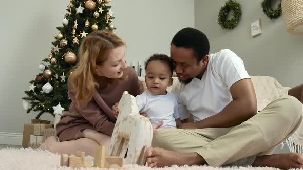 A Multiethnic Family is Having Fun By the Christmas Tree