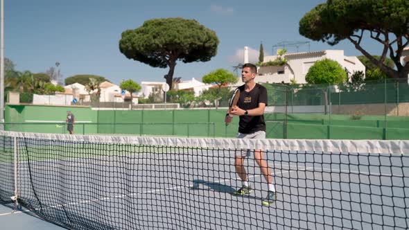 A Male Athlete at a Paddle Competition in Motion Hits the Ball with a Racket