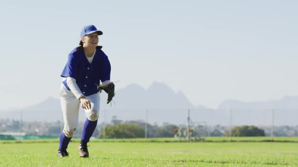 Caucasian female baseball player, fielder catching and dropping ball on baseball field