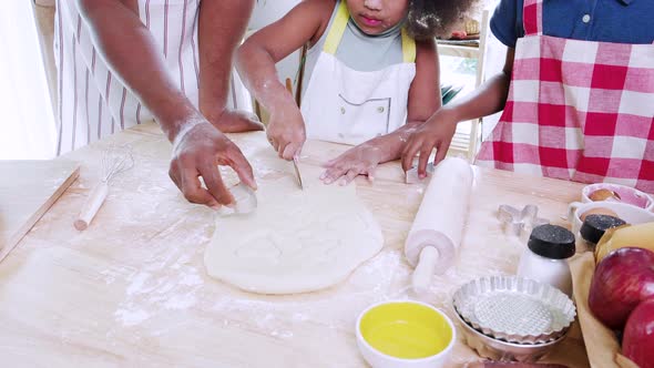 Happy joyful black people family having fun singing in the kitchen, cooking together at home