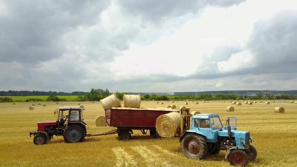 Semi Truck Loading Straw Bales. Semi truck and tractor loaded straw bales in countryside