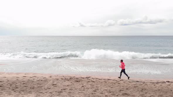 Woman is doing cardio fitness exercises on seashore