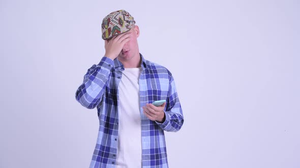 Stressed Young Hipster Man Using Phone and Getting Bad News
